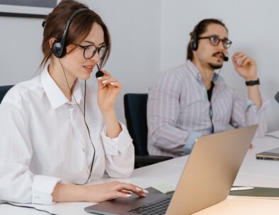 co-workers on headsets with laptops